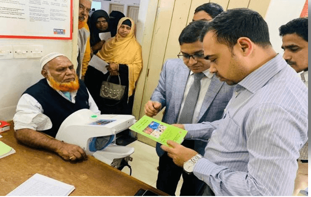 Officials and clinicians reviewing a patient's treatment card at a facility